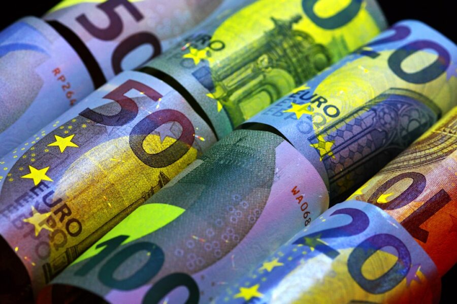 Rolled euro banknotes in various denominations.